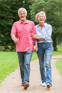 Active and happy senior couple walking in the park